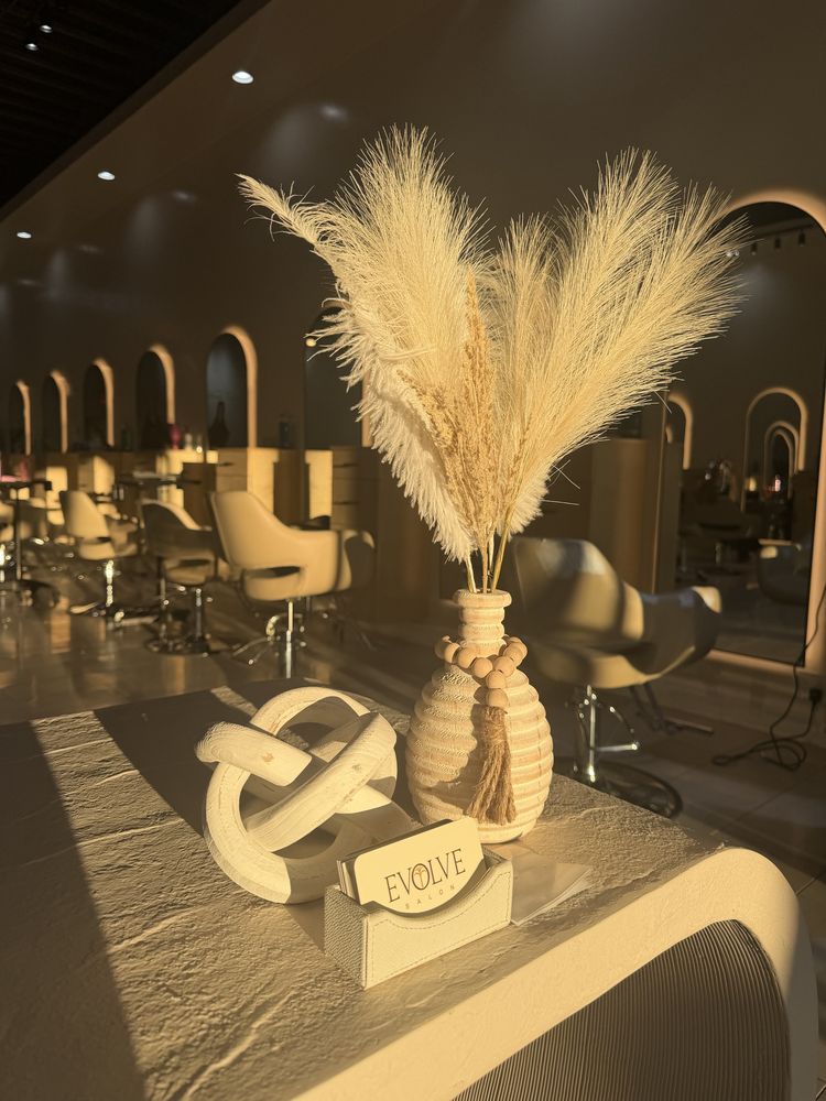 Reception details at Evolve Salon with pampas grass, a wooden bead garland and Evolve Salon business cards