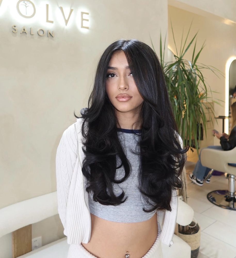 Waist-length dark brown hair with voluminous curls and waves through the ends